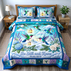 Be Still And Know Hummingbird quilted 3-piece bedding set on a made bed with two matching pillow shams