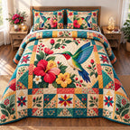 Cozy Hummingbird quilted 3-piece bedding set on a made bed with two matching pillow shams