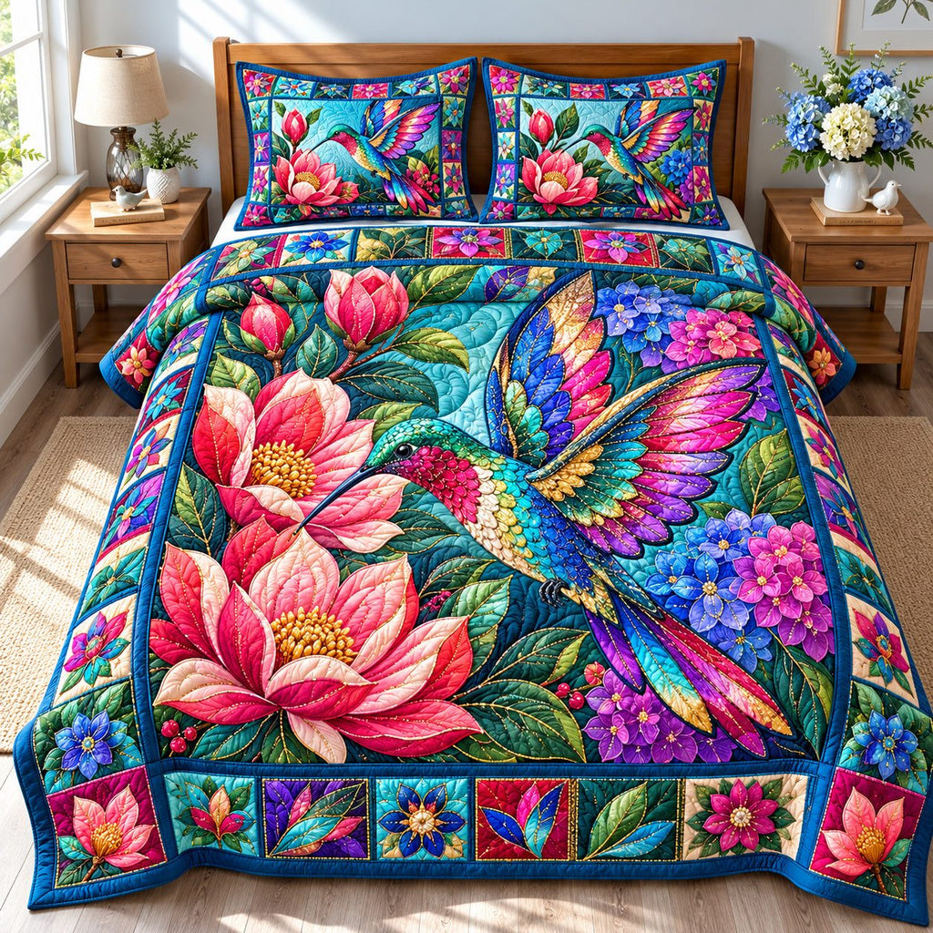 Hummingbird Floral Glow quilted 3-piece bedding set on a made bed with two matching pillow shams