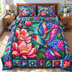 Hummingbird Floral Glow quilted 3-piece bedding set on a made bed with two matching pillow shams