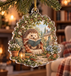 Custom-shaped acrylic ornament with a reading hedgehog beneath a leafy arch and gold hanging cord.