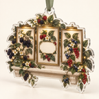 One christmas ornament with a coordinated trio of slim antique-brass botanical frames, flowing blackberry, raspberry, blueberry and red-currant brambles, jewel-like berries, sage leaves, cream blossoms, glass vase, warm picture lights, amber fireflies and a blank ivory plaque.
