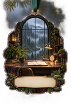 One christmas ornament with a rain-covered arched window overlooking a misty pine forest and river, a walnut writing desk, blank notebook and parchment name plaque.