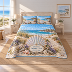 Example WELCOME / EMMA & LIAM / JUNE 15, 2026 ivory plaque before a pearlescent scallop fan on driftwood, sea lavender, dune grasses, turquoise cove and lighthouse headland.