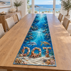 A rectangular table runner printed with coral-and-shell letters D O T, dolphin, octopus and sea turtle in a deep reef canyon.