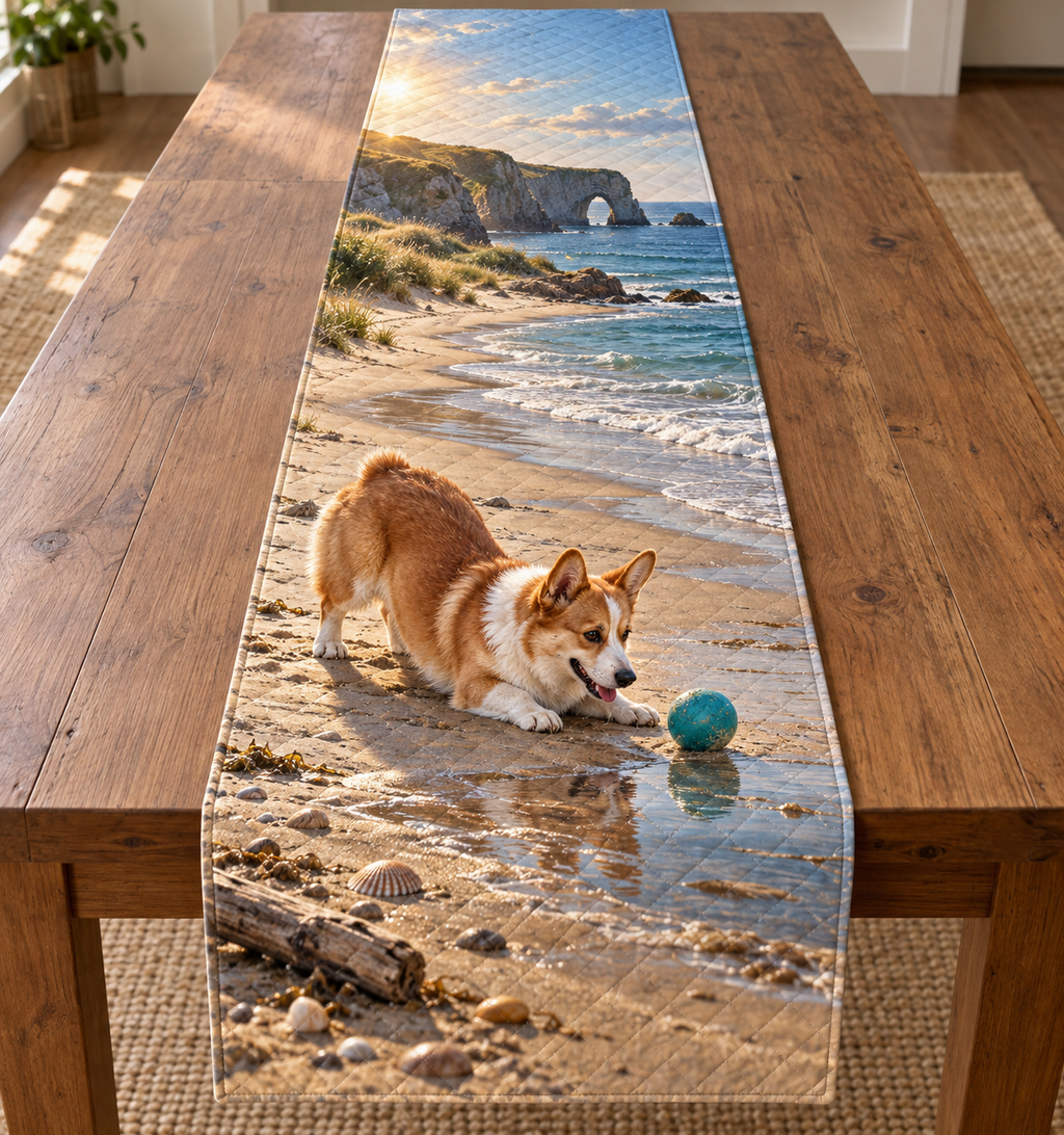 A rectangular table runner printed with a playful corgi and turquoise ball beside a tidepool, dunes and distant sea arch.