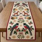 Four illustrated collared trogons frame two cranberry toy rocking giraffes with ochre spots and navy rockers, with orange halves, cedar cones, holly, mistletoe and ochre snowflakes on ivory with cranberry binding. Flat printed Christmas artwork. Includes one table runner. Quilted cotton hero with visible sewn quilting and fabric drape.