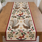 Four illustrated superb lyrebirds frame two cranberry toy rocking kangaroos with navy rockers and ochre saddles, with pear halves, cedar cones, holly, mistletoe and ochre snowflakes on ivory with cranberry binding. Flat printed Christmas artwork. Includes one table runner. Quilted cotton hero with visible sewn quilting and fabric drape.
