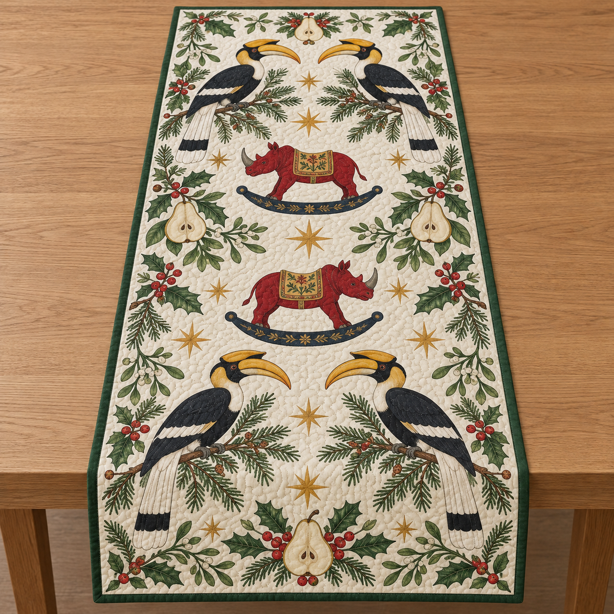 Four illustrated great hornbills with curved yellow bills and casques frame two cranberry toy rocking rhinoceroses with ochre saddles and navy rockers, pear halves, cedar, holly, mistletoe and ochre stars on ivory with green binding. Flat printed Christmas artwork. Includes one table runner. Quilted cotton hero with visible sewn quilting and fabric drape.