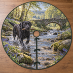 A round tree skirt printed with a black Labrador carrying a stick through a bluebell woodland creek.