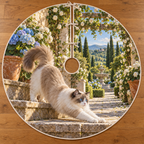 A fluffy Ragdoll stretches forward down sunlit stone steps beside blue hydrangeas, with a receding rose pergola and distant fountain.