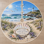 Example WELCOME / EMMA & LIAM / JUNE 15, 2026 ivory plaque before a pearlescent scallop fan on driftwood, sea lavender, dune grasses, turquoise cove and lighthouse headland.
