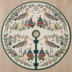 One ivory quilted circular tree skirt with four black-tailed godwits cranberry toy sailboats navy sails pear halves fir mistletoe holly snowflake baubles green binding centered hole continuous slit three ties