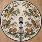 Four illustrated laughing kookaburras with broad bills and barred tails frame two brown toy rocking wombats with ochre saddles and navy rockers, orange halves, cedar, holly, mistletoe and ochre snowflakes on ivory with navy binding. Flat printed Christmas artwork. Includes one circular tree skirt with center opening and tie closure. Visible sewn quilting and continuous radial opening.