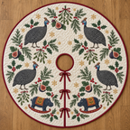 Four illustrated helmeted guineafowl with white-spotted charcoal bodies and blue heads frame two navy toy rocking hippopotamuses with ochre saddles and cranberry rockers, fig halves, cedar, holly, mistletoe and ochre snowflakes on ivory with cranberry binding. Flat printed Christmas artwork. Includes one circular tree skirt with center opening and tie closure. Visible sewn quilting and continuous radial opening.