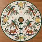 Four illustrated rufous-tailed jacamars with emerald backs and cinnamon bellies frame two cranberry toy rocking aardvarks with ochre saddles and navy rockers, starfruit cross sections, cedar, holly, mistletoe and ochre stars on ivory with green binding. Flat printed Christmas artwork. Includes one circular tree skirt with center opening and tie closure. Visible sewn quilting and continuous radial opening.