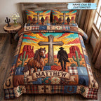 Personalized Cowboy Cross Desert Sunset quilted 3-piece bedding set on a made bed in a softly lit bedroom