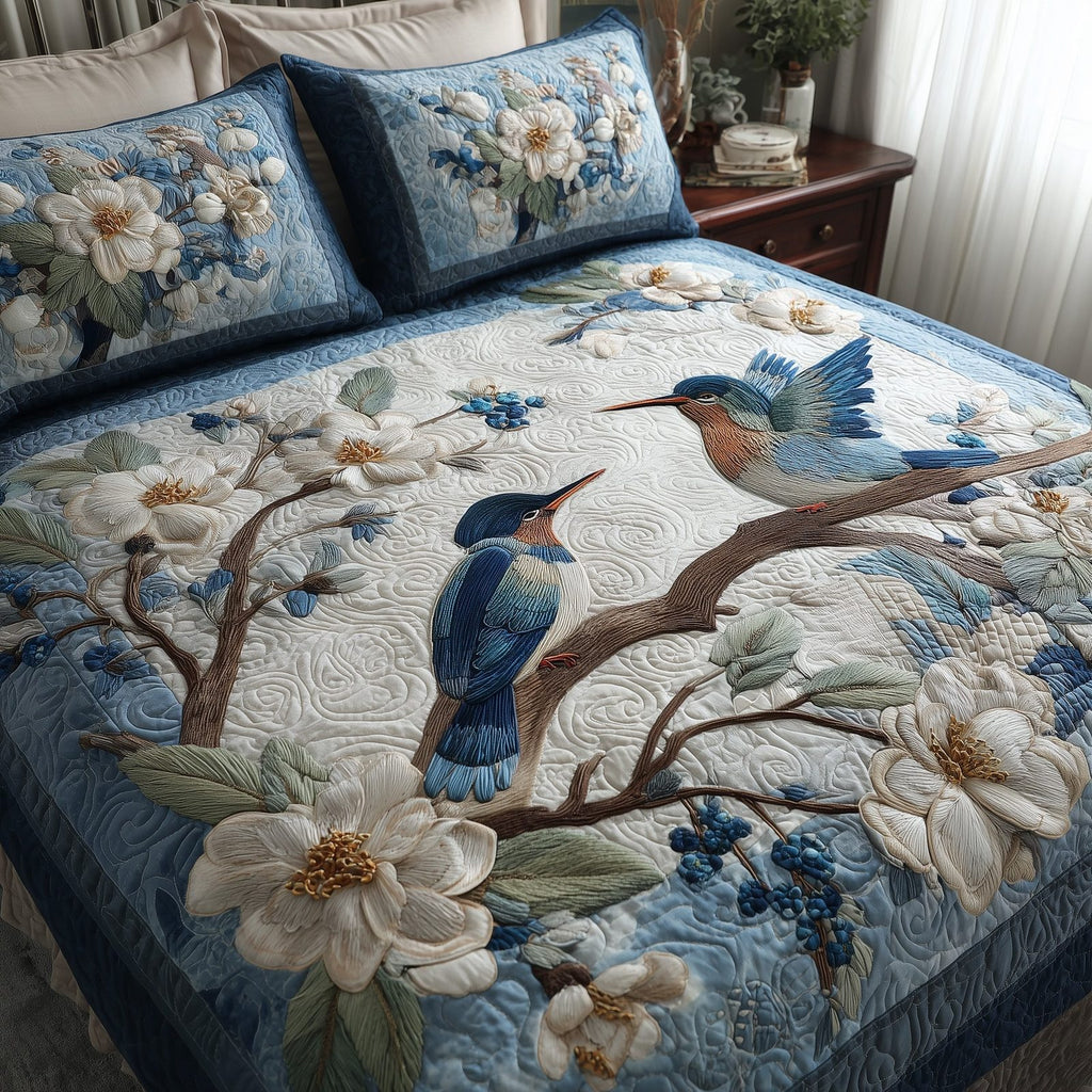 Winter Hummingbird Love Branch quilted 3-piece bedding set on a made bed in a winter-styled bedroom